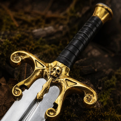 Close-up of black leather grip, gold brass pommel and ornate skull crossguard on the He-Man Power Sword
