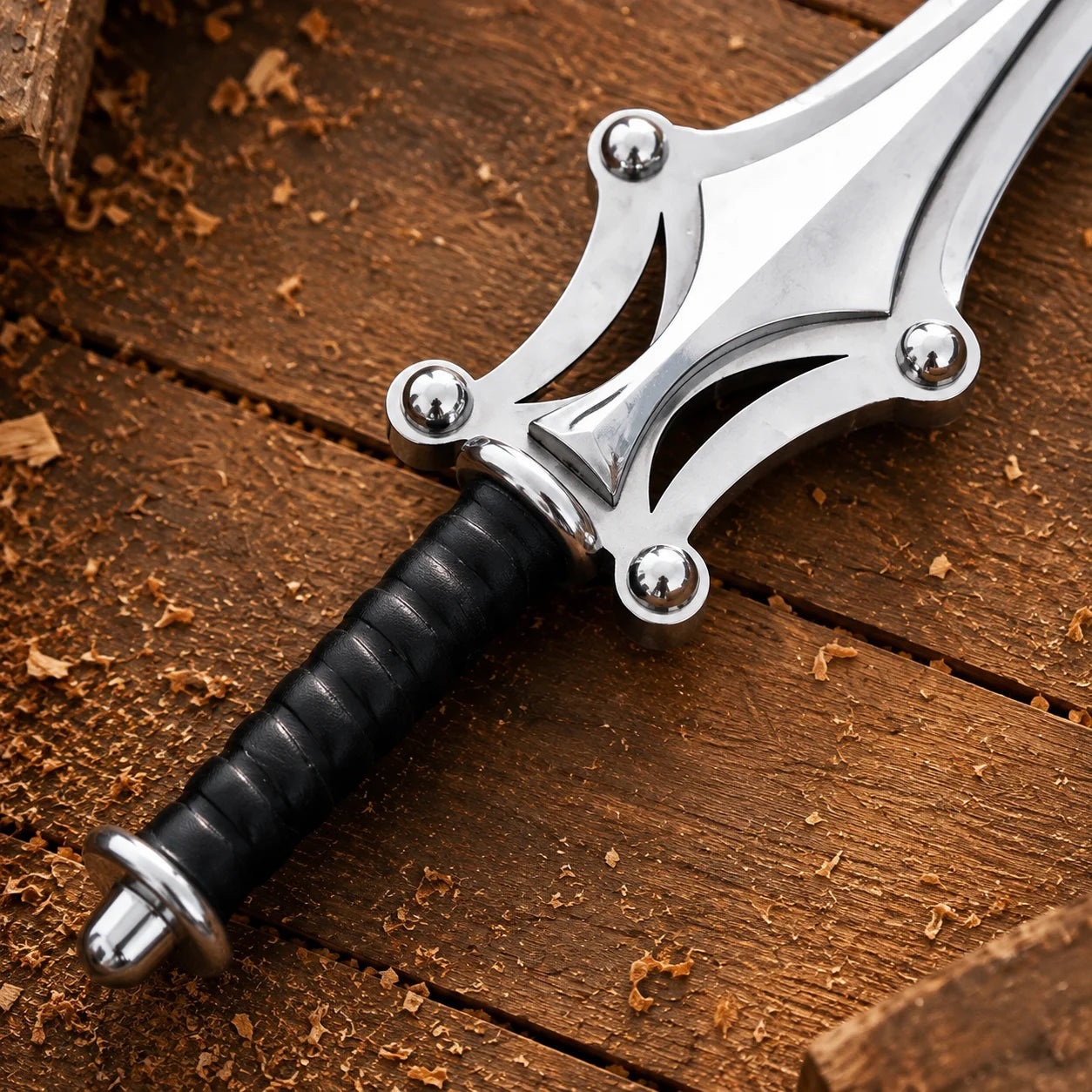 Close-up of Power Sword black leather-wrapped grip, silver pommel and sculpted open-work guard with rounded accents