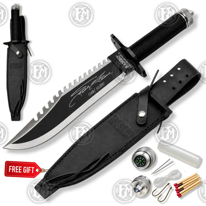 White-background Rambo First Blood Part II knife replica with black sheath and survival-themed accessories shown alongside.