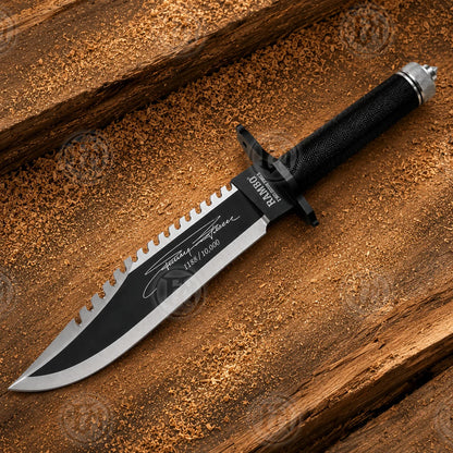 Full diagonal Rambo First Blood Part II knife replica showing black blade, silver edges and wrapped handle.